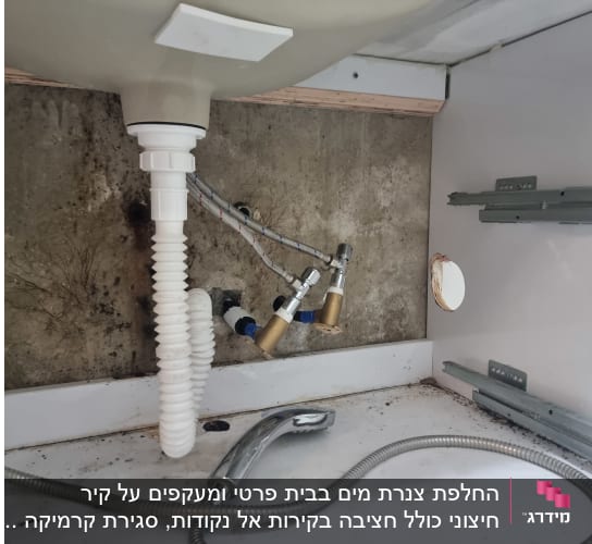 כיור עם צינורות וכלי עבודה מתחת לכיור